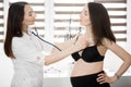 Female medicine doctor holding stethoscope to pregnant woman standing for encouragement, empathy, cheering,support