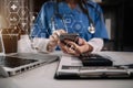 Female medicine doctor, physician or practitioner in lab room writing on blank notebook and work on laptop computer.