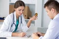 Female medicine doctor prescribing pills to her male patient