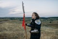 Female medieval knight with spear poses in armor