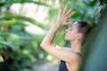 Female meditating and practicing yoga in tropical rainforest. Beautiful young woman practicing yoga outdoor with Royalty Free Stock Photo