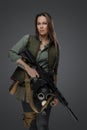 Female mercenary with rifle isolated on grey background