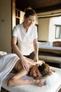 Female message therapist giving a massage at a spa