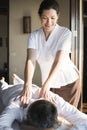 Female message therapist giving a massage at a spa