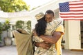 Female mid adult african american soldier embracing smiling husband on arrival at home Royalty Free Stock Photo