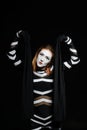 Female mime artist with neutral emotions on black background Royalty Free Stock Photo