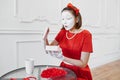 Female mime artist in red costume, scene with gift Royalty Free Stock Photo