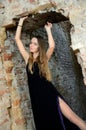 Woman in blak dress inside ruins