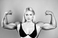 Female model keeps fit and healthy, raises hands and shows muscles, power. Strong muscle arms. Funny sport, woman with Royalty Free Stock Photo