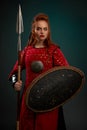 Serious female knight posing with shield and spear.