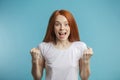 Female model with red loose hair and natural make-up posing over blue background. Royalty Free Stock Photo