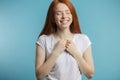 Female model with red loose hair and natural make-up posing over blue background. Royalty Free Stock Photo