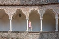 Udine - Female model standing between columns and arches of renaissance Venetian gothic style arcade