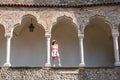 Udine - Female model standing between columns and arches of renaissance Venetian gothic style arcade