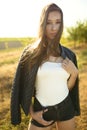 Female model standing on the field lit by warm sun rays, her hair blowing in the wind. Royalty Free Stock Photo