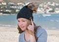 Female model wearing gray knitted beanie with Bluetooth speakers