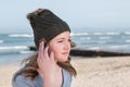 Female model wearing green knitted beanie with Bluetooth speakers