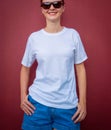 Female model wearing white blank t-shirt on the background of an burgundy wall. Royalty Free Stock Photo