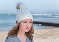 Female model wearing white knitted beanie with Bluetooth speakers