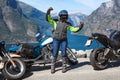 Female motorcyclist from bikers group triumphs on the mountain road overlooking the Norwegian fjords and nature, travel on Norway