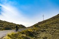 Female mountain bike cyclist riding uphill along mountain road in Spain