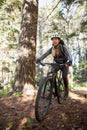 Female mountain biker riding bicycle in the forest