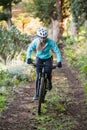 Female mountain biker riding bicycle in the forest Royalty Free Stock Photo