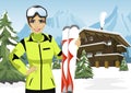 Female mountain skier standing in front of chalet in winter ski resort