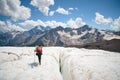 Female mountaineer enjoying the beauty of the glacier walks on the glacier in the crampon and sunglasses. Against the