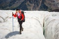 Female mountaineer enjoying the beauty of the glacier walks on the glacier in the crampon and sunglasses. Against the