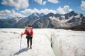 Female mountaineer enjoying the beauty of the glacier walks on the glacier in the crampon and sunglasses. Against the