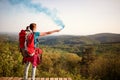 Female mountaineer sending smoke signal to hikers group