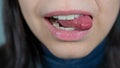 Female mouth close-up, woman shows tongue. Female bites her tongue Royalty Free Stock Photo