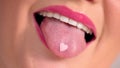 Female mouth open and put a heart shape pill on tongue