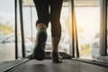 Female muscular feet in sneakers running on the treadmill at the gym, Lower body at legs part of fitness girl running on running Royalty Free Stock Photo