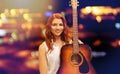 Female musician with guitar over night city lights Royalty Free Stock Photo