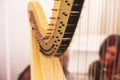 Female musician harpist playing harp during symphonic concert, with other musicians in the background, close up hands of the woman Royalty Free Stock Photo