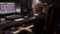 Female musician uses electric piano in recording studio