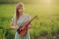 Female musician violinist holding a violin in her hands in sunset light Royalty Free Stock Photo