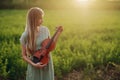 Female musician violinist holding a violin in her hands in sunset light Royalty Free Stock Photo