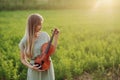 Female musician violinist holding a violin in her hands in sunset light Royalty Free Stock Photo