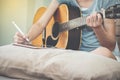 Female musicians play guitar and write songs using the tablet.This image is blurred and soft focus. Royalty Free Stock Photo