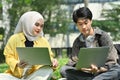 Female Muslim college student and classmates making research, working on group project on laptop at outdoor Royalty Free Stock Photo