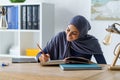 Female Muslim student reading book