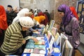 Female muslims buying religious book during celebrating Islamic holiday Mawlid