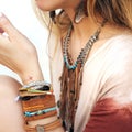 Female neck and hands with many boho bracelets, leather necklace and earrings with feathers Royalty Free Stock Photo