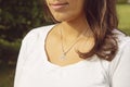 Female neckline wearing tiny silver chain with silver pendant