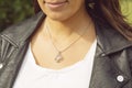 Female neckline wearing tiny silver chain with silver pendant