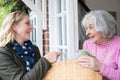 Female Neighbor Helping Senior Woman With Shopping