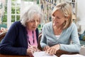 Female Neighbor Helping Senior Woman To Complete Form Royalty Free Stock Photo